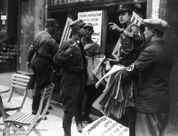 SA-Angehörige beim Kleben von Boykottplakaten vor einem jüdischen Geschäft in München (1. April 1933)